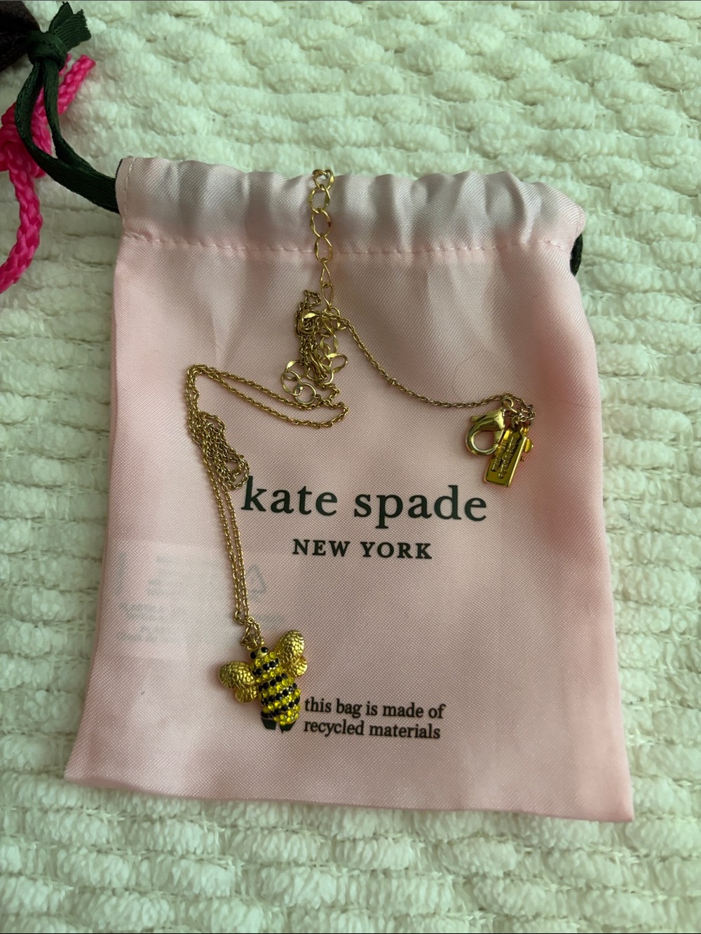 kate spade gold bee pendant necklace with pink pouch.